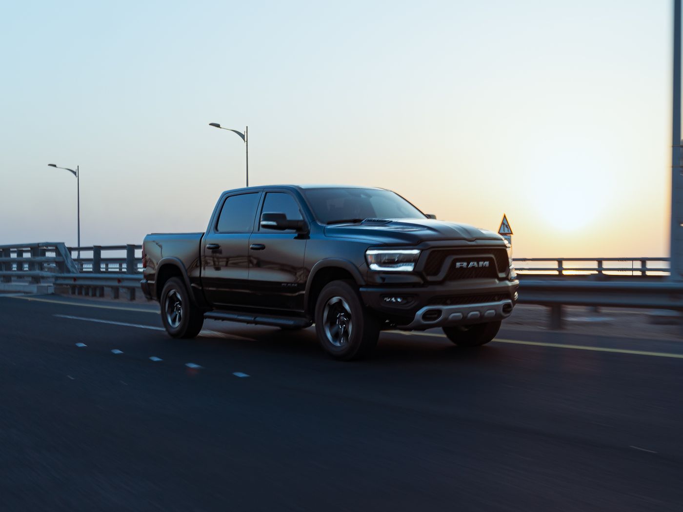 Ram pickup truck hauling freight on the highway at sunrise